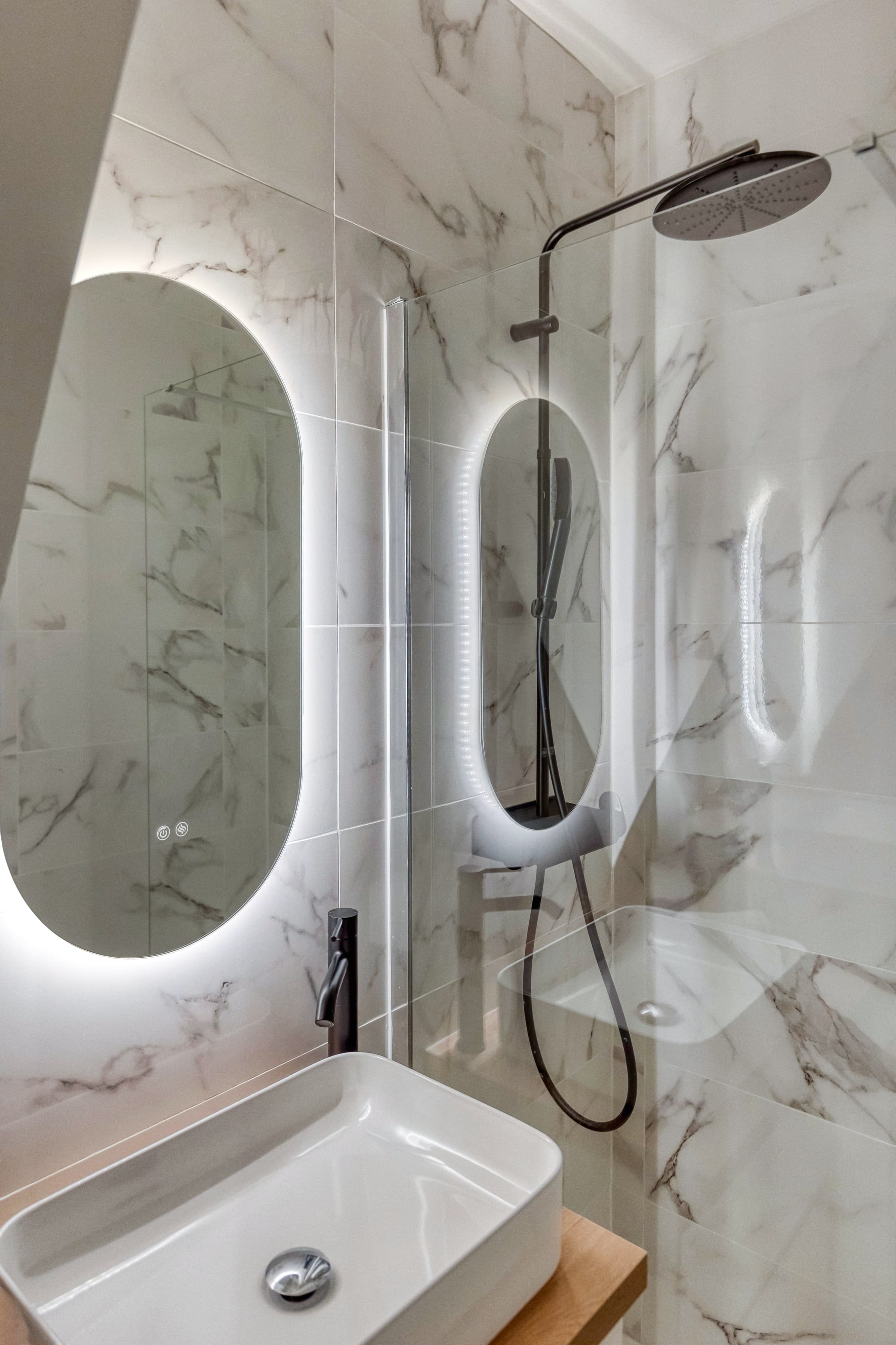 Salle d'eau aux matières claires avec miroir arrondi