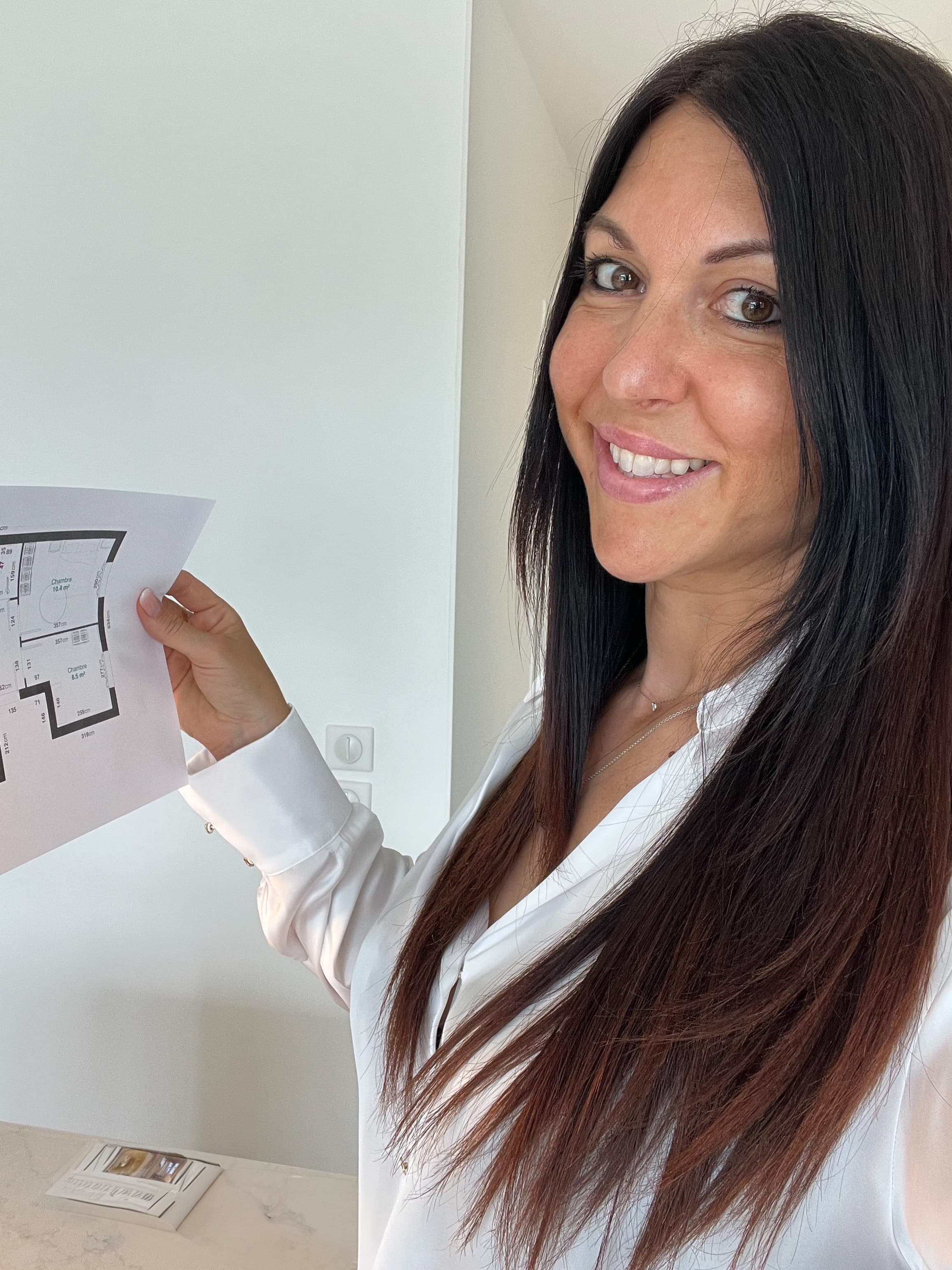 Emma Charnot tenant un plan de décoration intérieure
